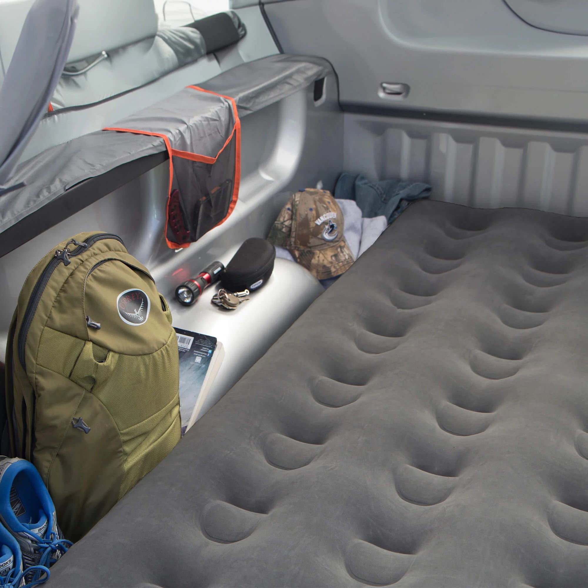 Truck bed air mattress inflating with a 12V air pump for quick setup.