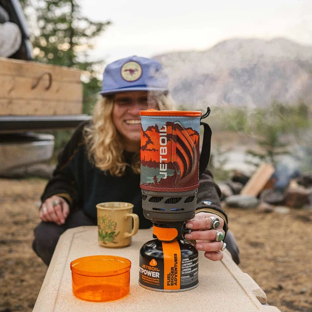 A side-angle view of the Jetboil Flash 1.0L with the lid open, showing the interior of the FluxRing cooking cup and the burner unit below.