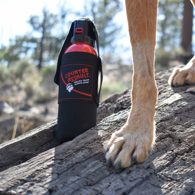 Bear spray with belt holster shown attached to a backpack, ideal for hiking, camping, and hunting