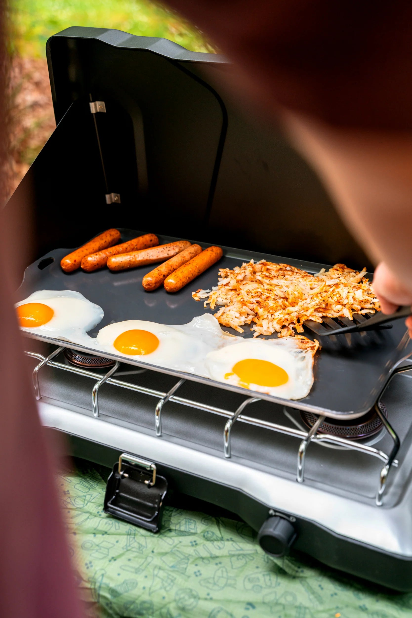 Non-stick aluminum camping griddle fitting most two-burner camp stoves, easy-clean surface for outdoor cooking