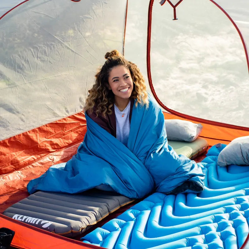 Versa Luxe Blanket folded into a compact pillow, showcasing its versatility for easy storage and travel.