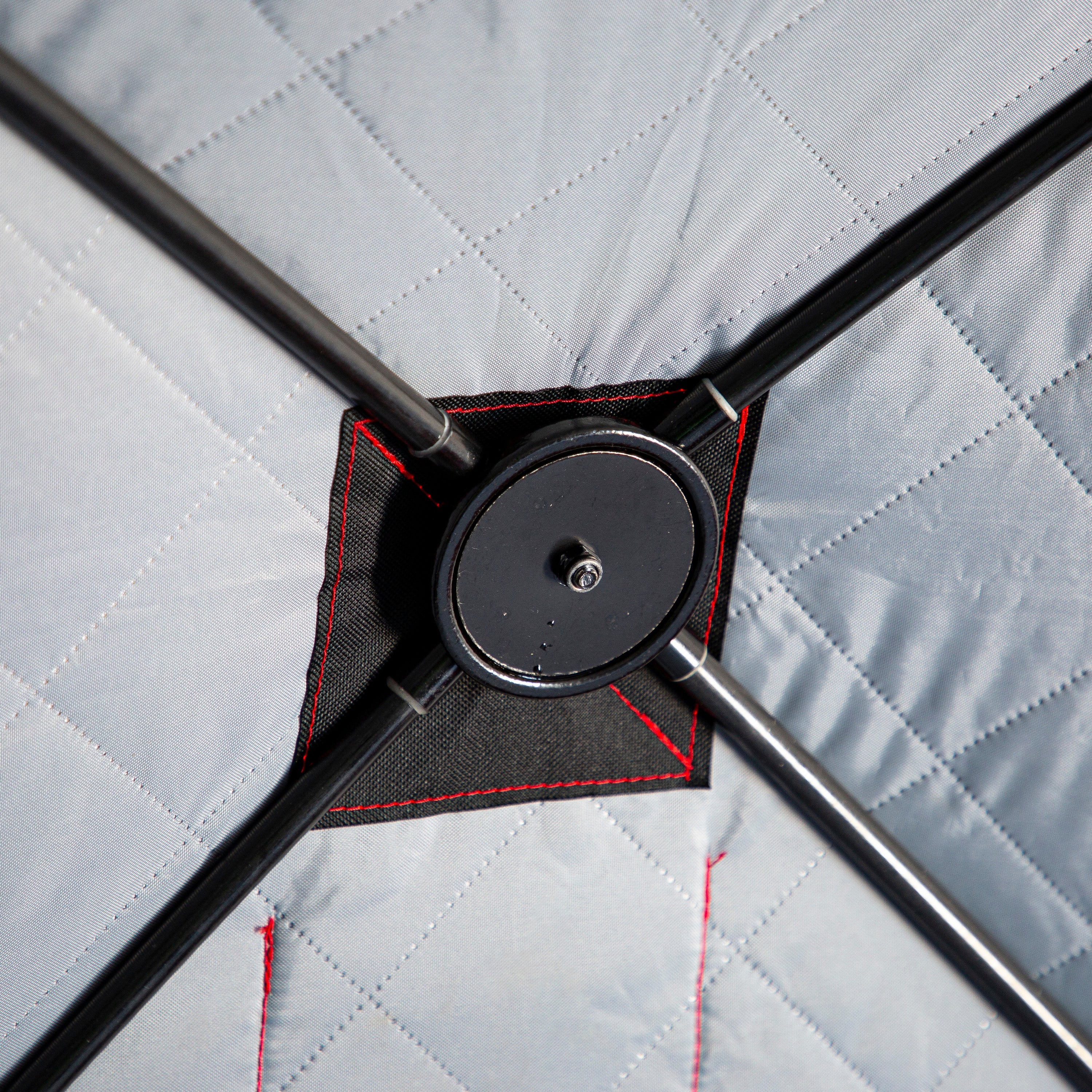 Close-up of a black metal bracket on a quilted gray surface