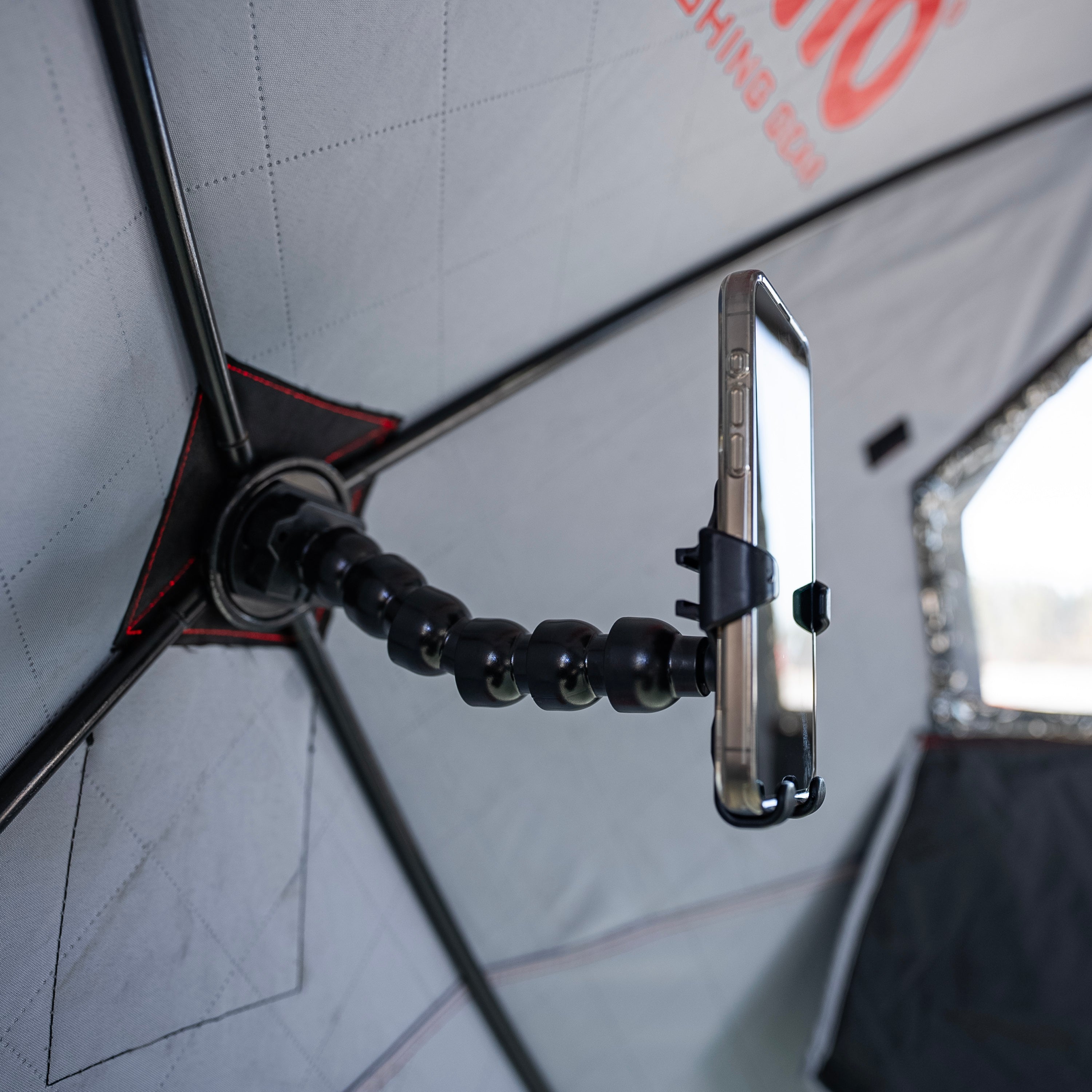 Close-up of the permanently mountable base of the E-Hub™ Phone Holder, attached securely to the wall of an Eskimo pop-up hub shelter.