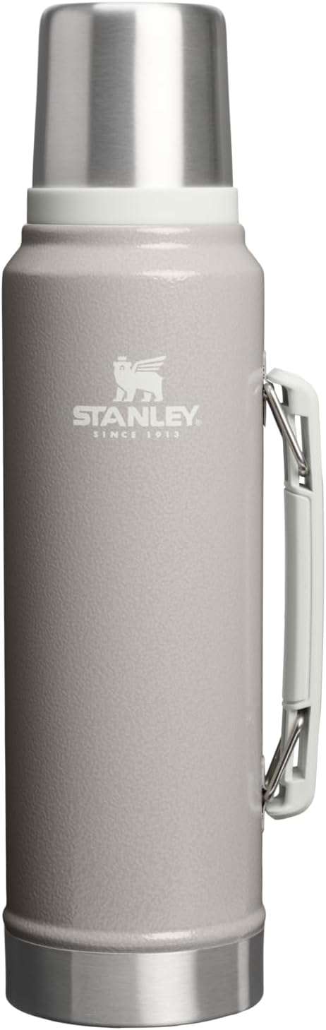 Stanley thermos bottle with silver lid and handle on a white background
