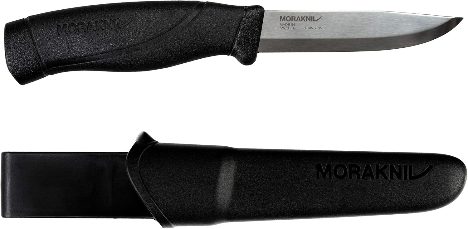 A sleek Morakniv Companion knife with a polished stainless steel blade and a black TPE rubber handle, lying next to its black polymer sheath with a belt clip.