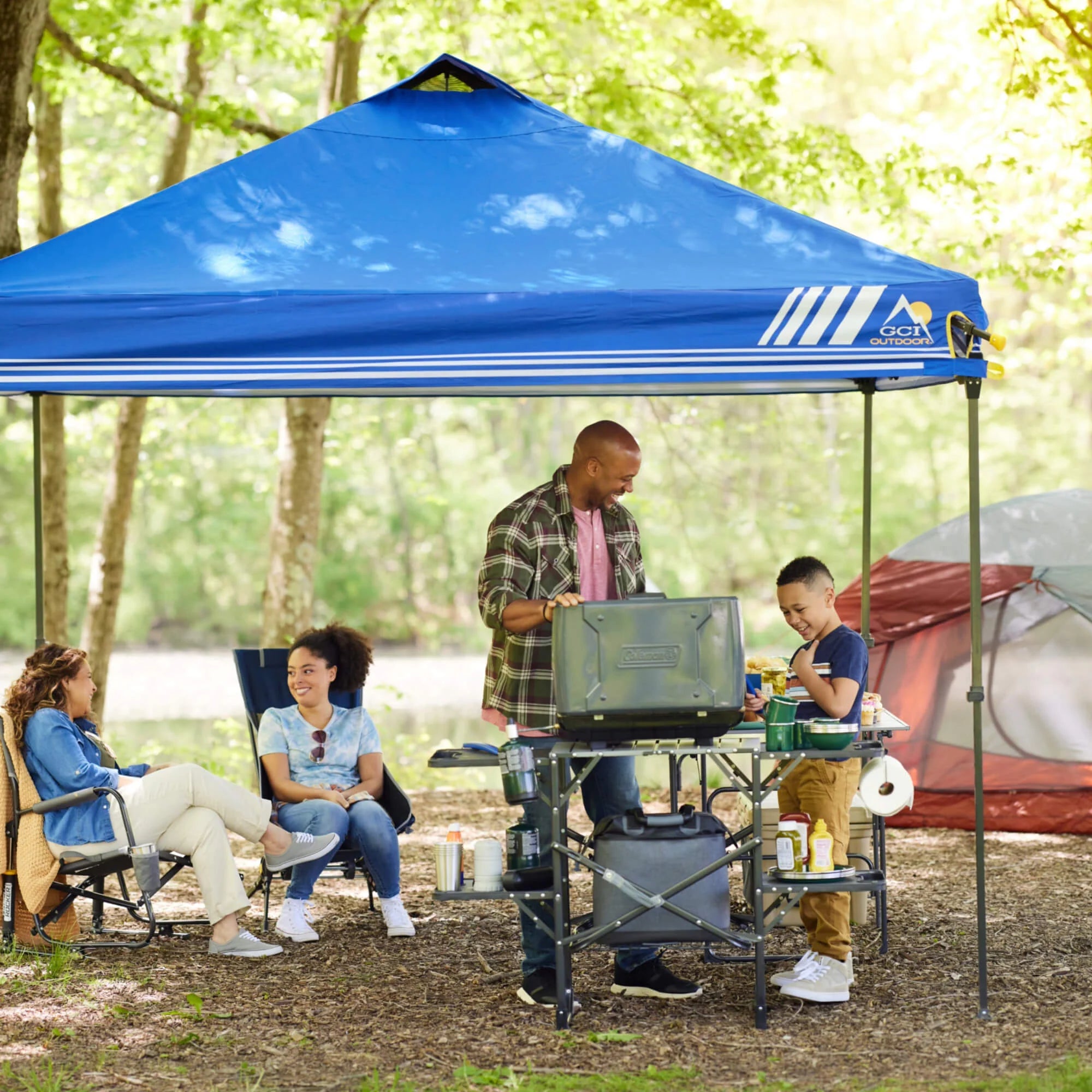 Outdoor cook station in use with grilling tools and ingredients.