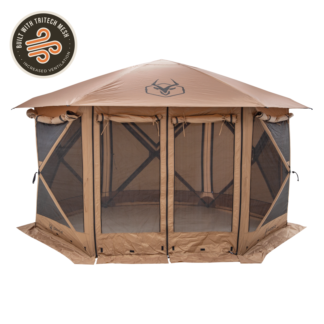 Gazelle G6 Cool Top gazebo in Badlands Brown, fully pitched in an outdoor forest setting—six-sided hub design with mesh-vented roof.