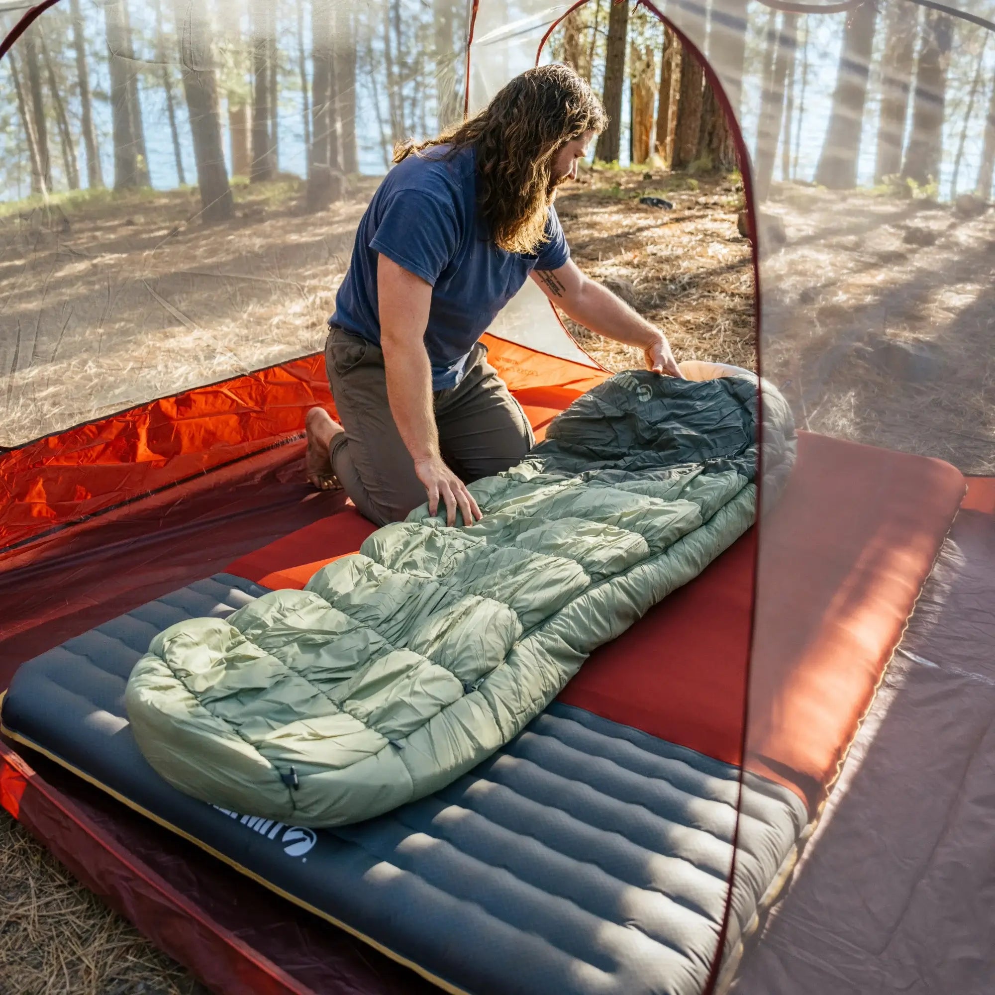 The Sojourn Stretch 0 sleeping bag compressed inside its compact sack, demonstrating its lightweight and packable design for easy transport.