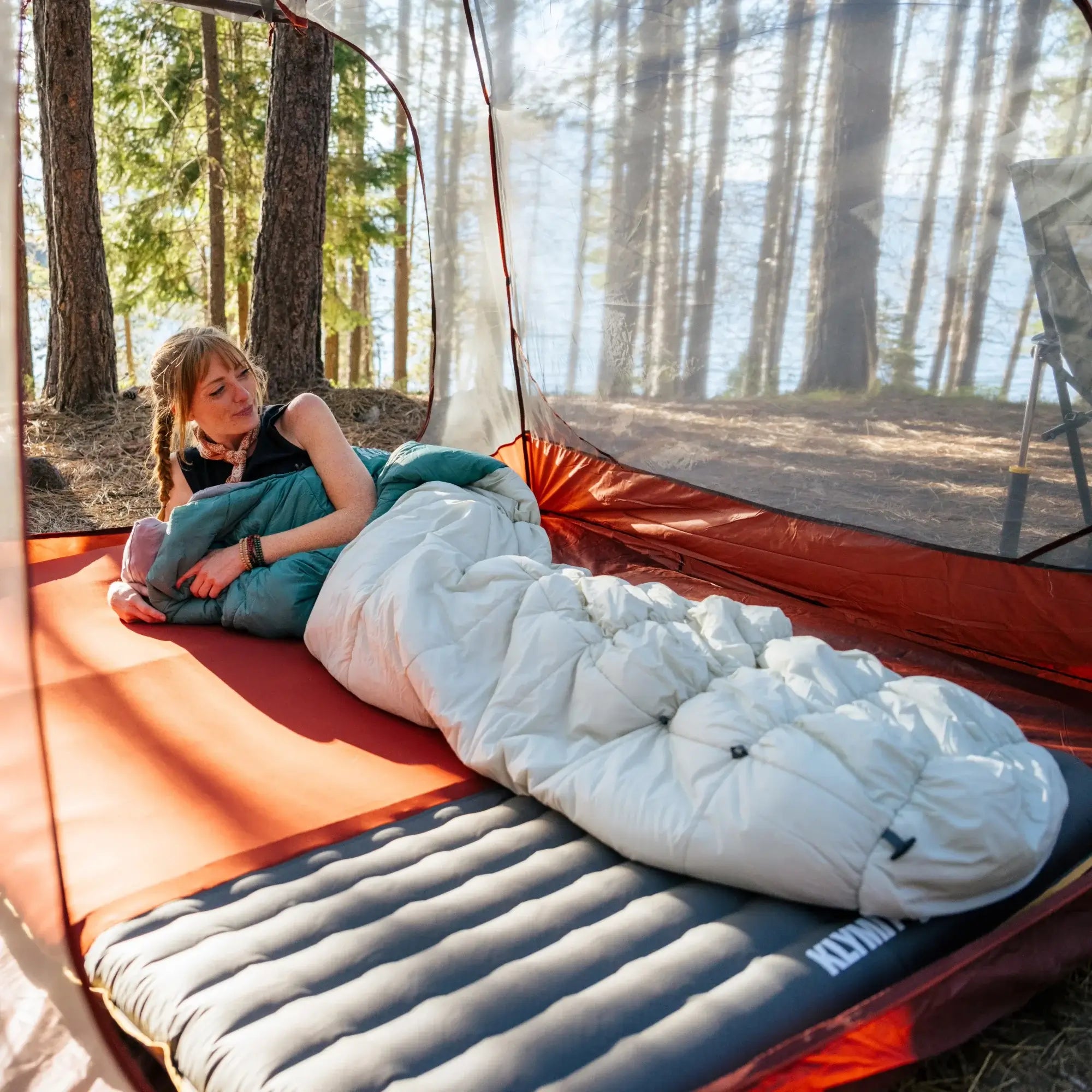 The Sojourn Stretch 20 sleeping bag packed inside its included compression sack, highlighting its compact design for easy storage and transport.