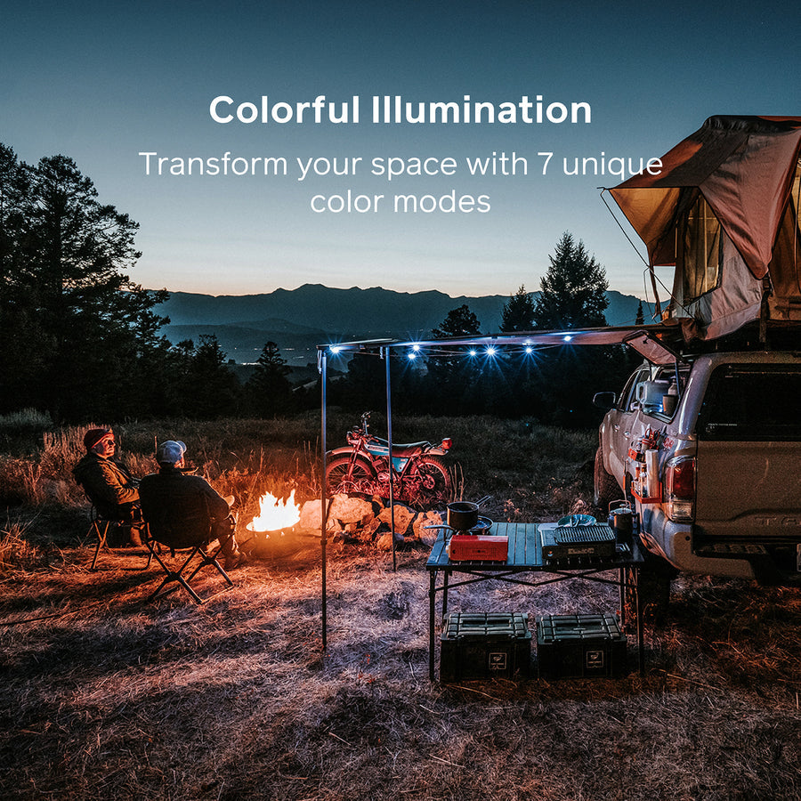 Two people camping outdoors with a tent, campfire, and colorful illumination system.
