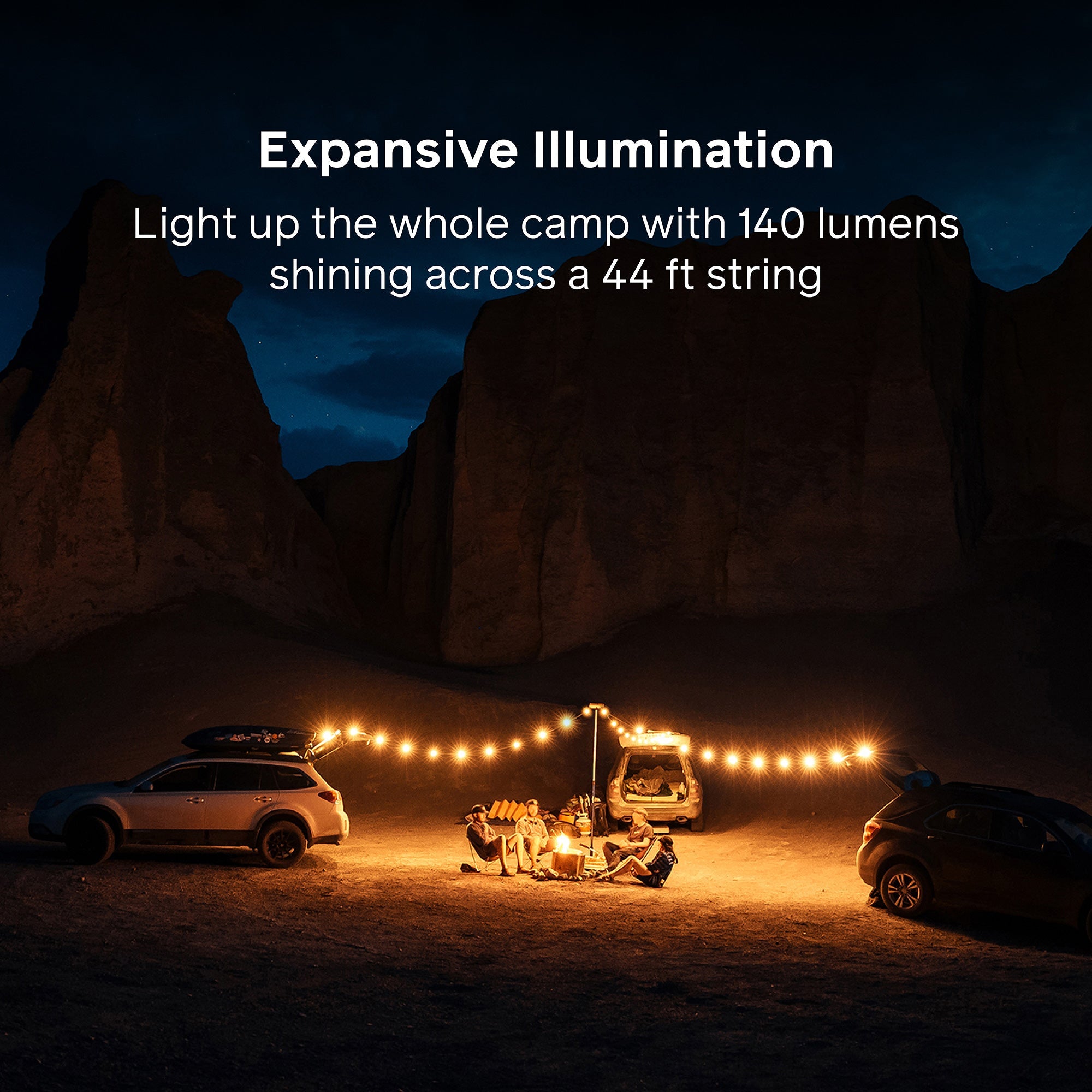 String lights illuminating a camping scene with cars and a tent in a desert landscape.