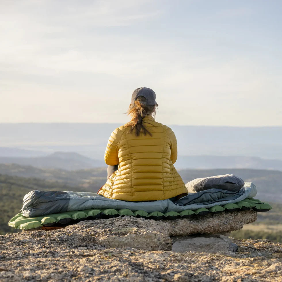 Compression Sack Storage: The sleeping bag packed inside its compression sack, illustrating its compact pack size for easy transport and storage.