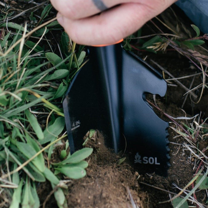 Close-up of Stoke Shovel multi-tool blade showing cord cutter, tent peg puller, and hex wrenches