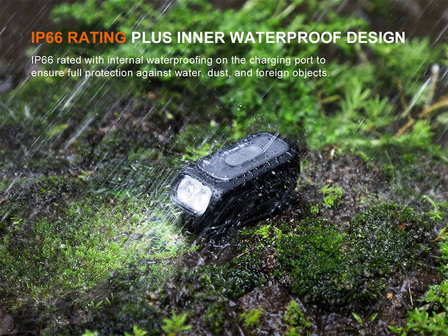 Black electronic device on a wet forest floor with water droplets, highlighting IP66 rating.