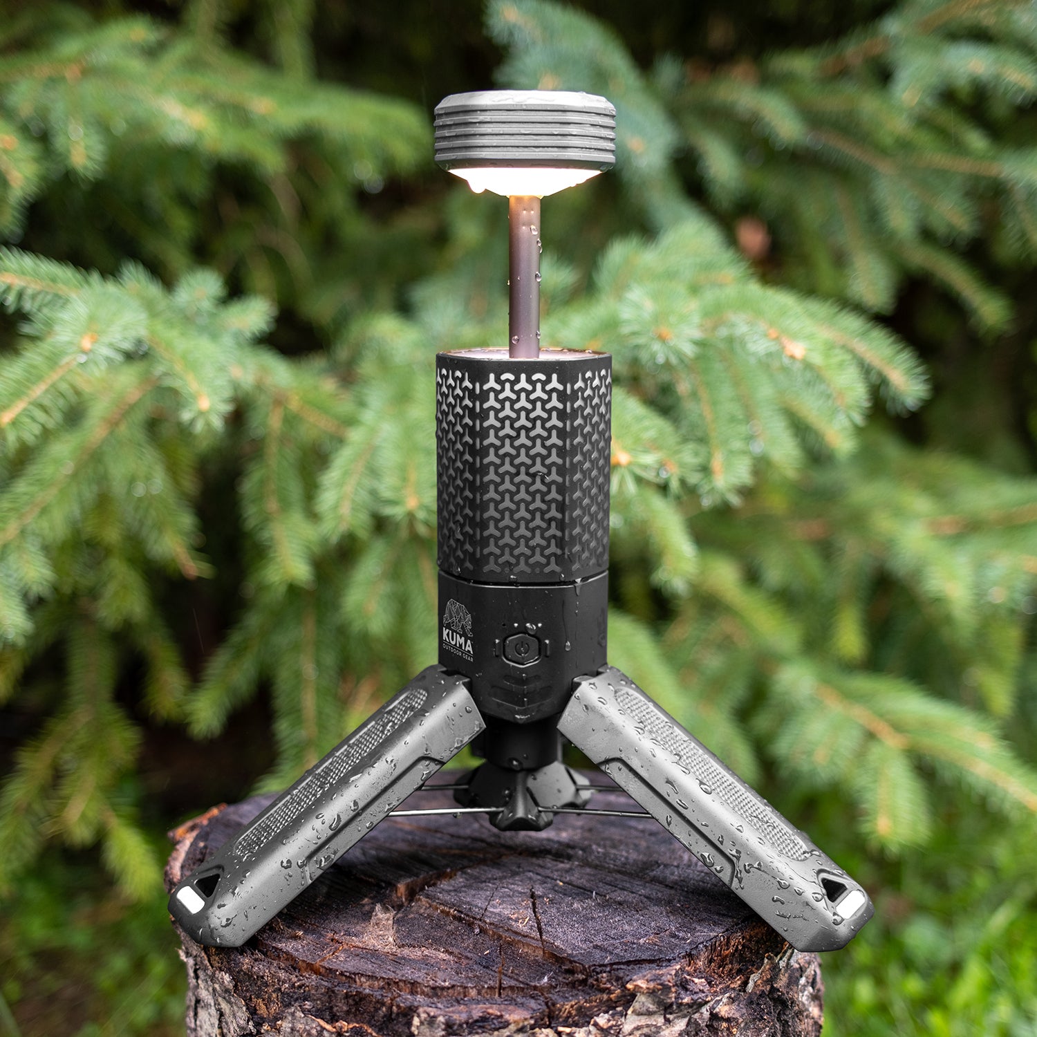 Portable camping stove on a tripod with a green forest background