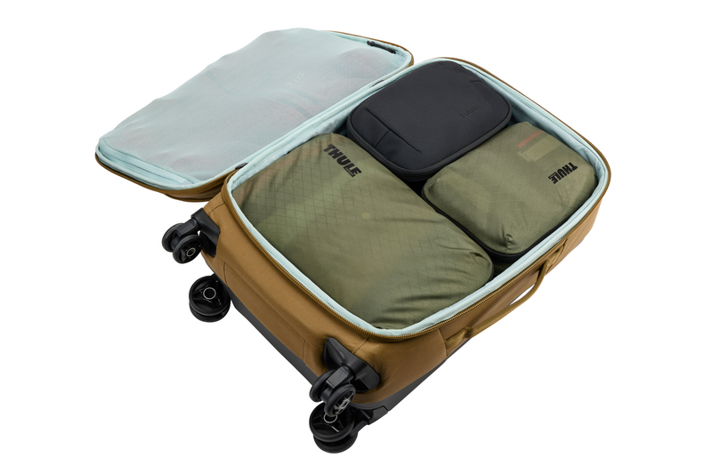 Thule medium packing cube containing jeans, leggings, and shirts, providing organized storage