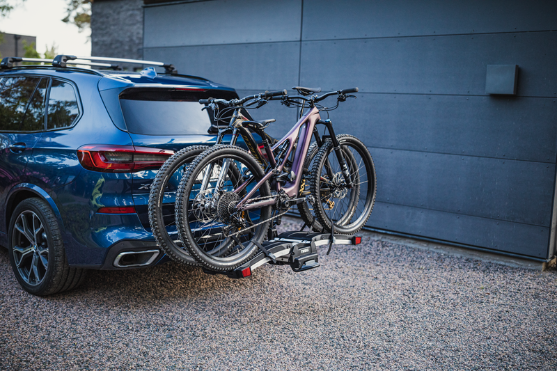Thule EasyFold XT 2 hitch bike rack being transported with integrated wheels and carrying handle