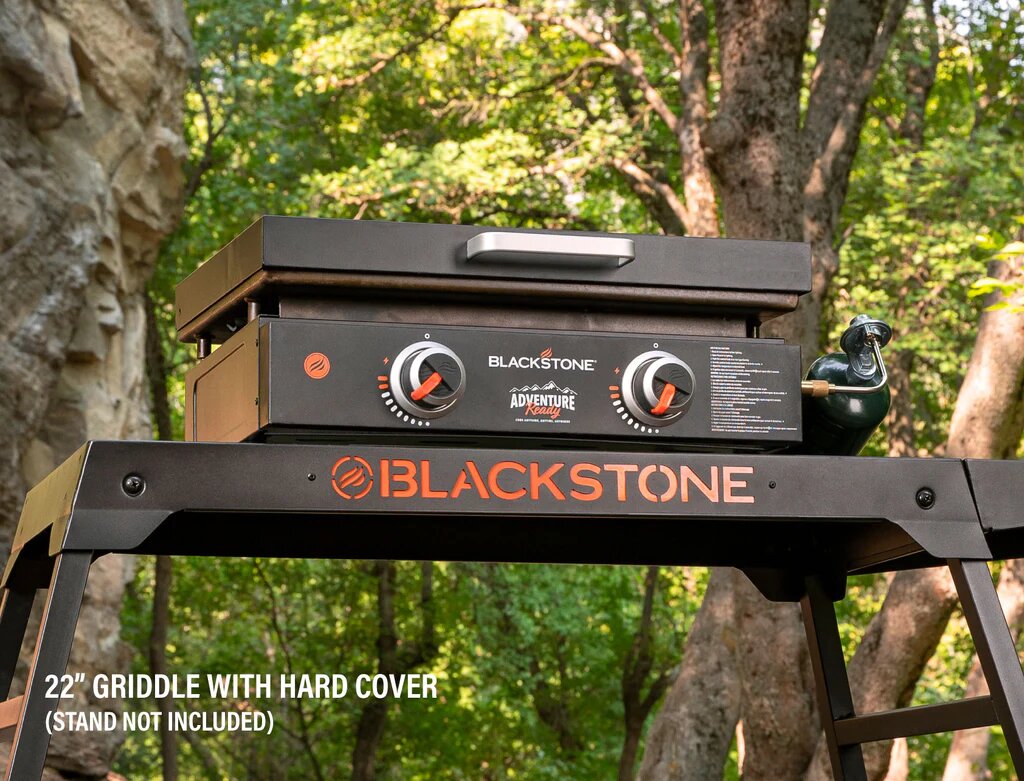 Close-up view of the Blackstone griddle’s stainless steel control knob and logo panel, highlighting the temperature dial details
