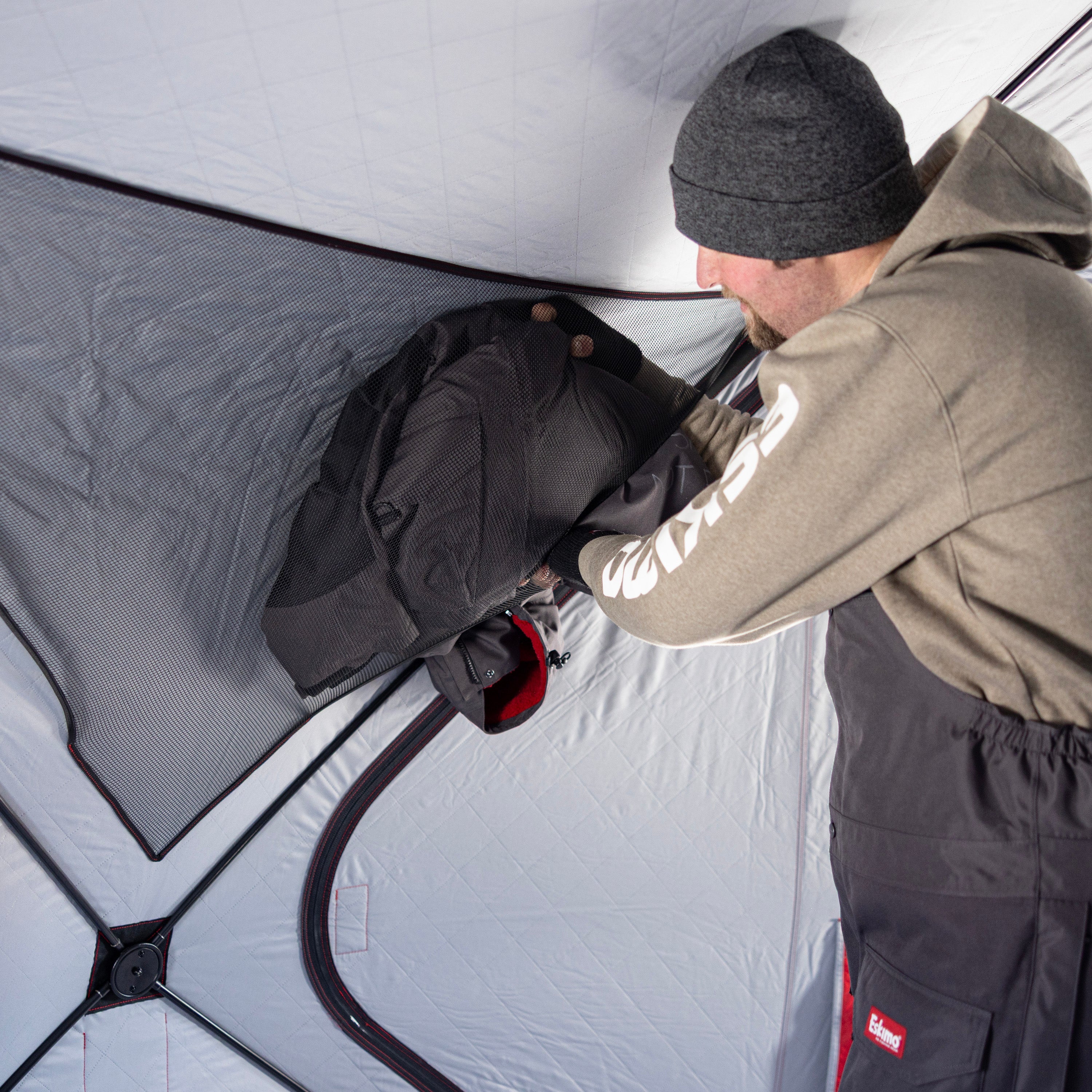 Group of anglers ice fishing inside Eskimo Outbreak 650XDP insulated hub shelter with spacious layout