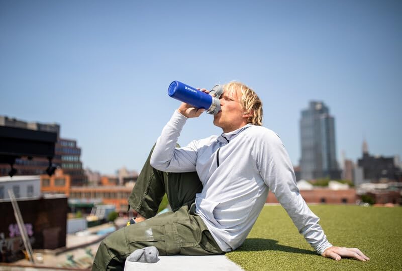 The Quick Flip GO Bottle fitting securely in a standard vehicle cup holder, demonstrating its compatibility for easy transport during travel. The bottle's compact design ensures it rides along comfortably