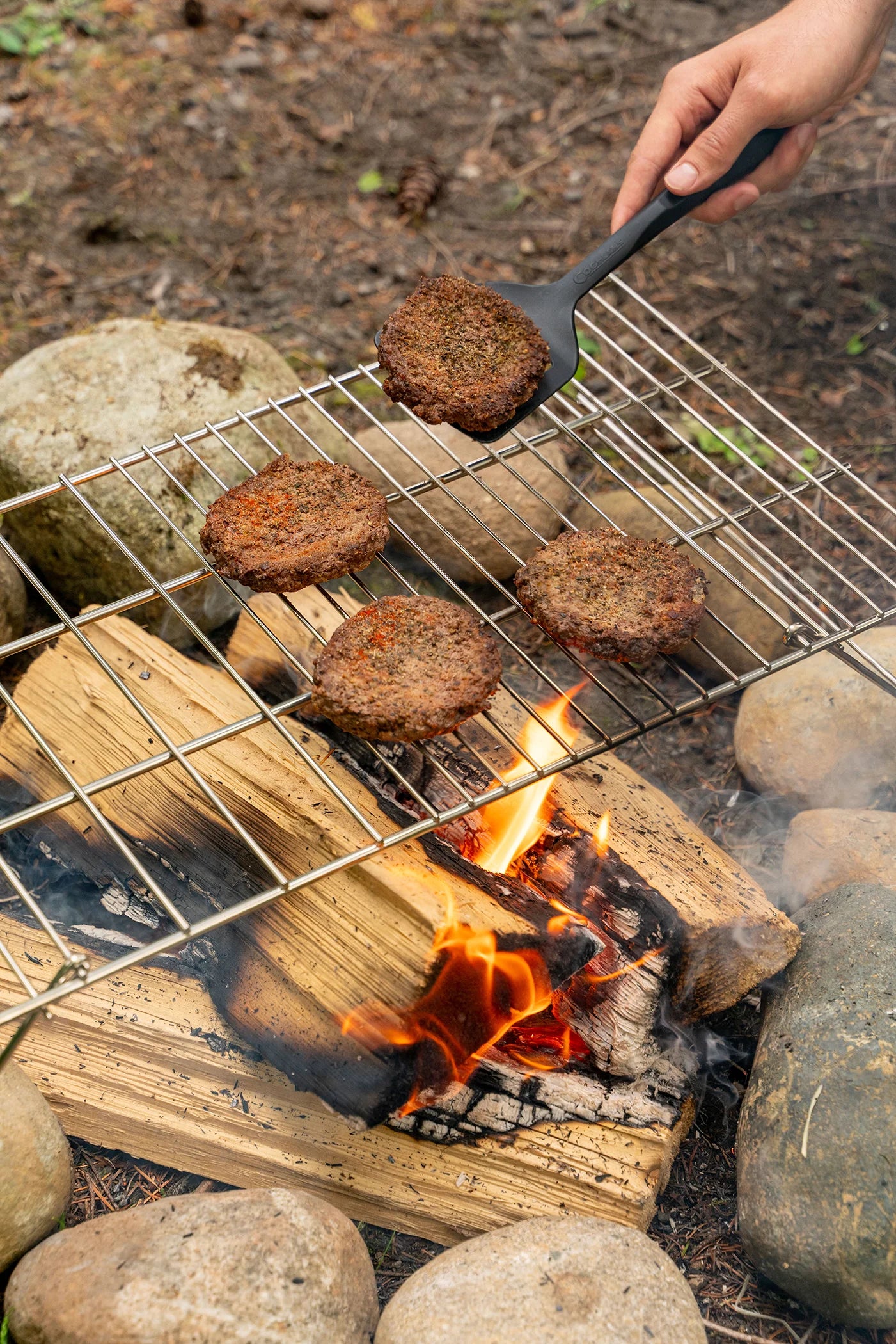 Coghlan’s heavy duty steel camp grill over a campfire