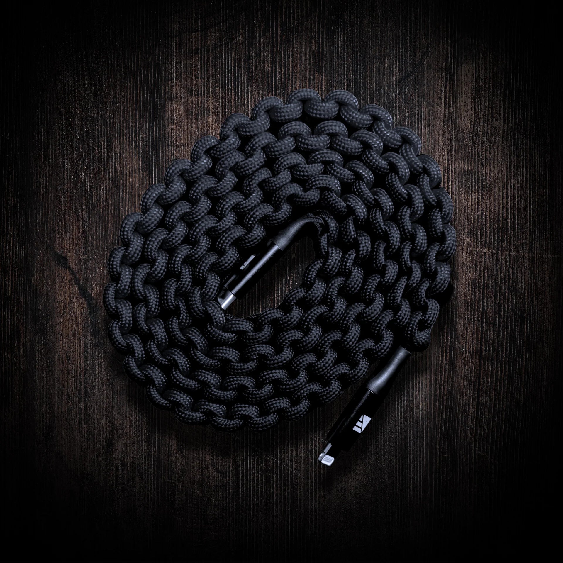 Close-up of the cable's colorful, durable paracord wrapping, showing the texture and strength of 20 feet (6.1 meters) of 550 lb (250 kg) certified cord. Text overlay highlights "Paracord Wrapped.