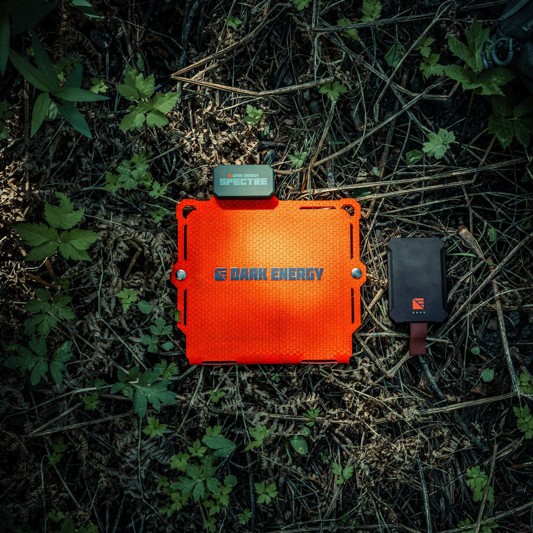 Orange power bank with 'Dark Energy' branding on a grassy ground