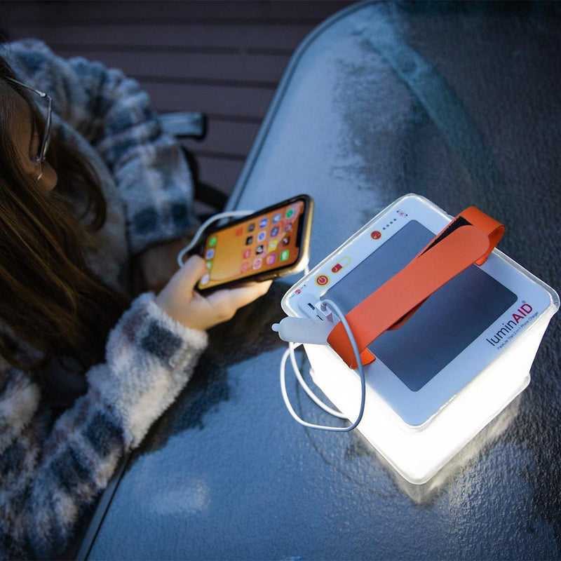 Titan Lantern with a 4000mAh battery, shown charging a smartphone through its USB-A port.