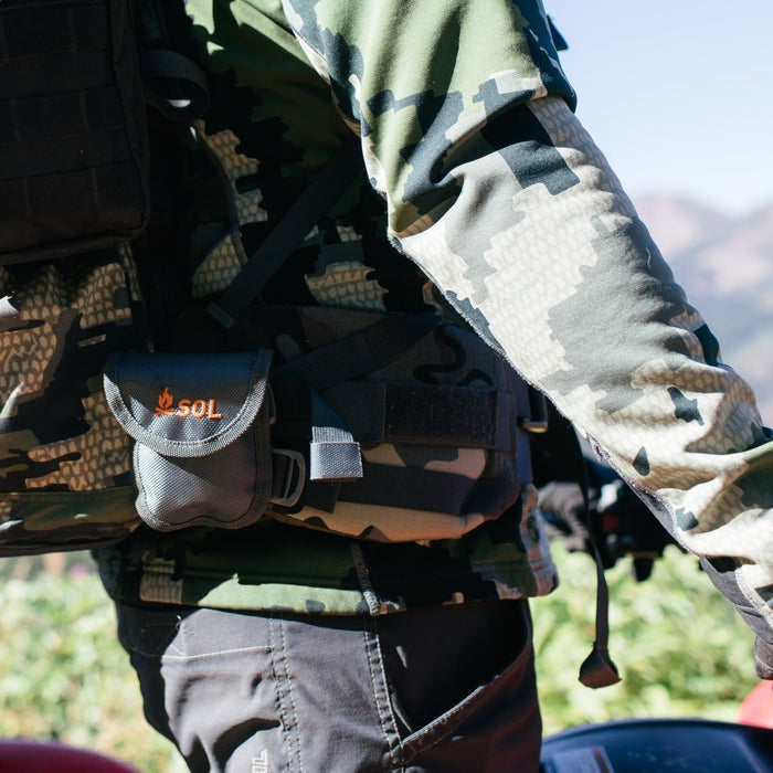 Portable manual chain saw stored in a rugged belt pouch for outdoor adventures