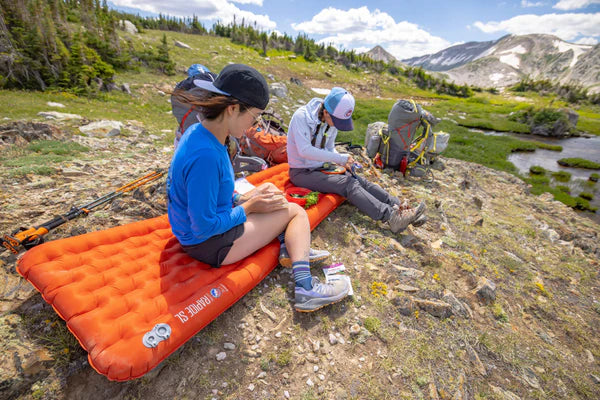 Backpacking air mattress with high-volume inflation sack included