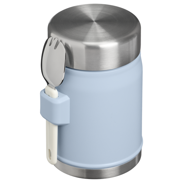 A light blue insulated container with a brushed stainless steel lid and base, featuring a matching light blue handle that holds a white and stainless steel spoon, shown on a white background.