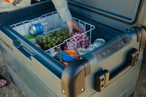 Cooler on grass beside tent, highlighting portable and durable design

