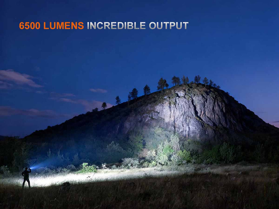 Person using a flashlight to illuminate a mountainous landscape with '6500 Lumens Incredible Output' text.