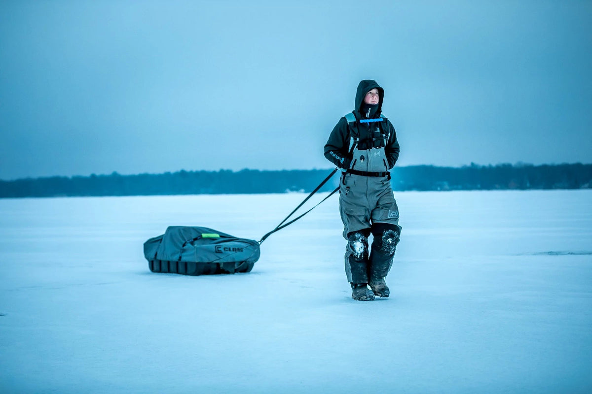 Adjustable ice fishing sled pulling harness over winter gear
