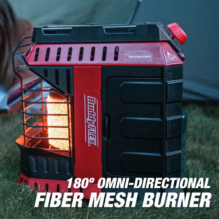 Red and black fiber mesh burner with visible flames on grass