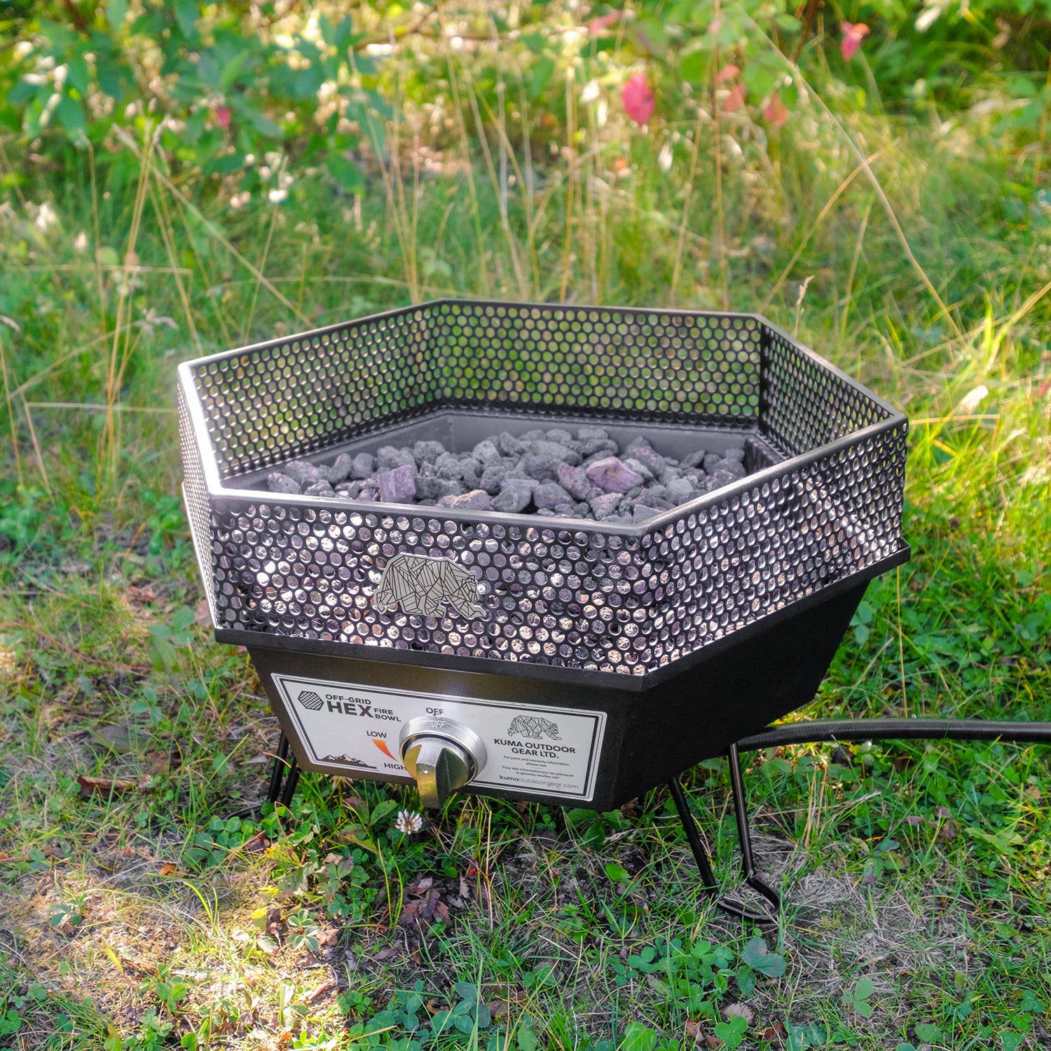 The fire pit set up at a campsite, surrounded by camping gear and outdoor chairs, showcasing its use for overlanding and outdoor adventures.

