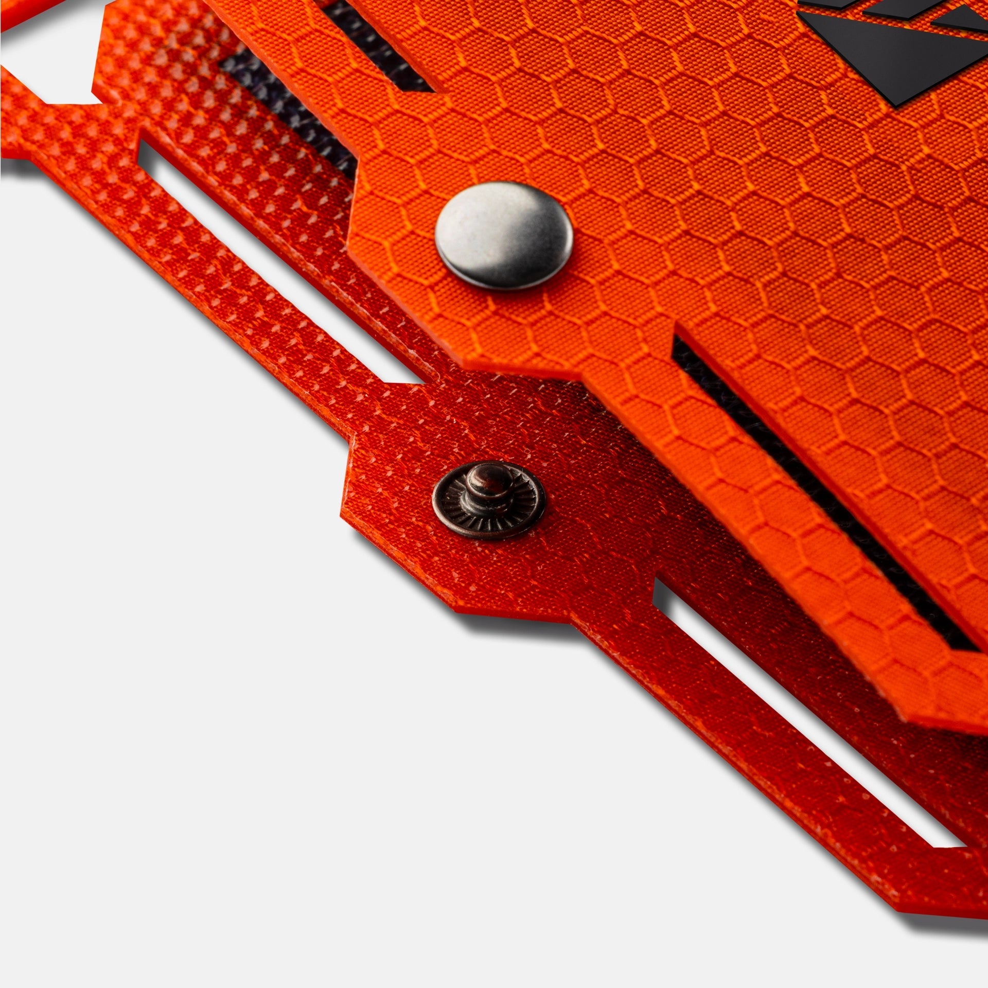 Close-up of an orange tool with a textured surface and metallic components on a white background