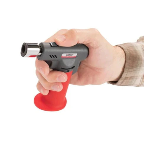 Hand holding a Zippo lighter with red base on a white background