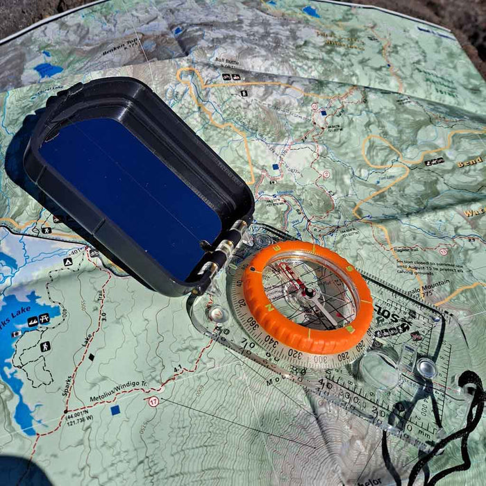 Sighting compass with glow-in-the-dark navigation markings

