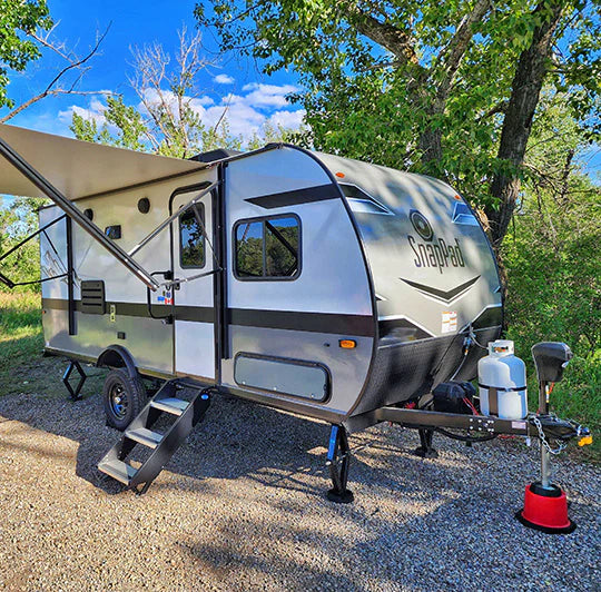 RV scissor jack equipped with SnapPad SnapJack SJ on uneven gravel terrain