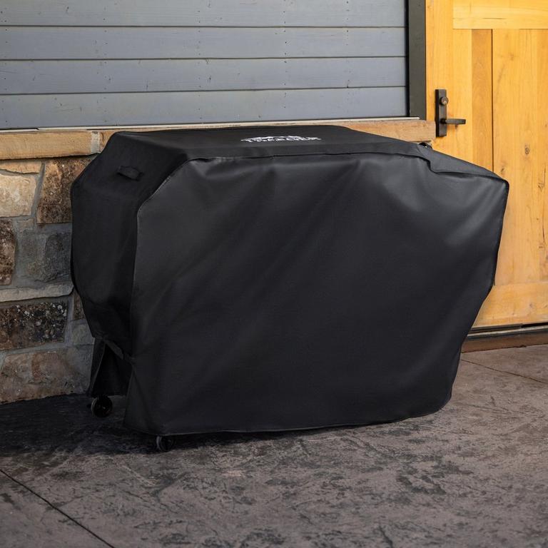 Black Irontop 4-Burner Full-Length Grill Cover with screen-printed logo, designed to protect outdoor griddles from rain, snow, sun, dirt, pollen, and debris.